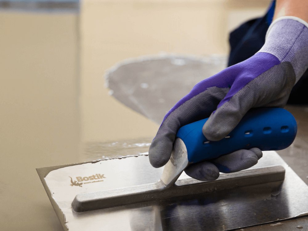 Image of smoothing compound being trowelled onto a floor