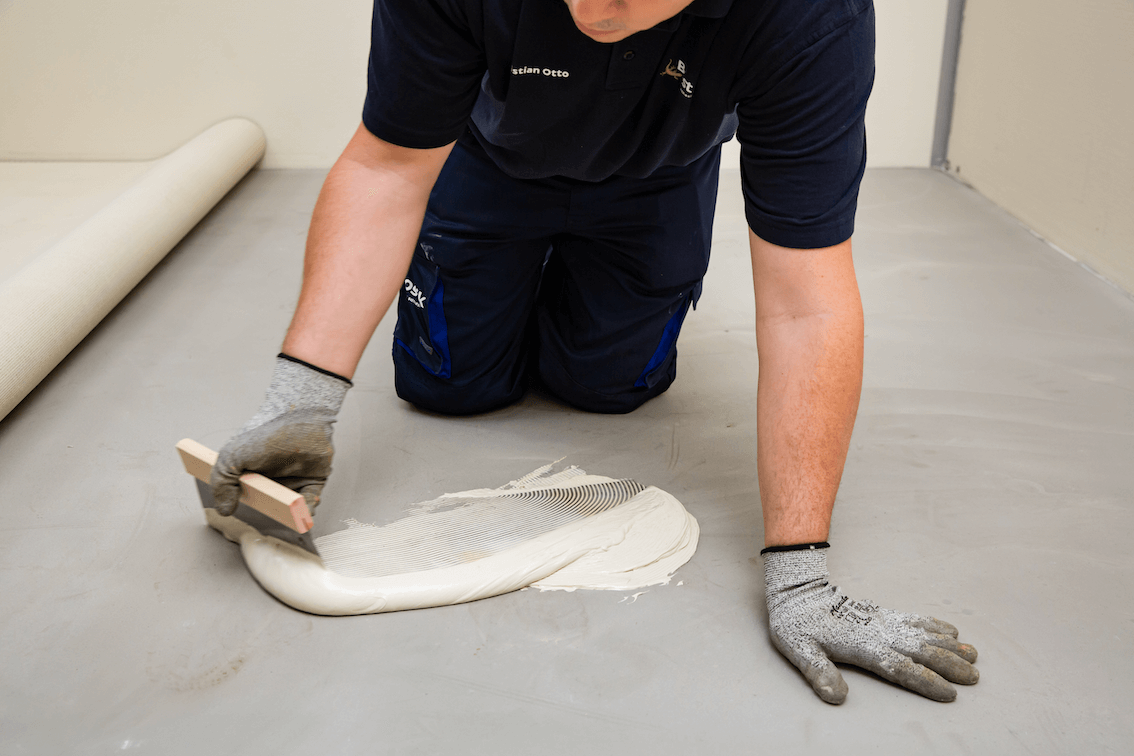 Flooring adhesive being trowelled onto a subfloor